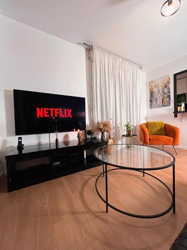 a living room with a coffee table and a television at SSP Suites- Cosy & Bel appartement 4 pièces 3 chambres 90M2 avec balcon in Épinay-sur-Seine