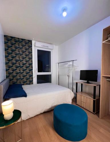 a bedroom with a large bed and a blue stool at SSP Suites- Cosy & Bel appartement 4 pièces 3 chambres 90M2 avec balcon in Épinay-sur-Seine
