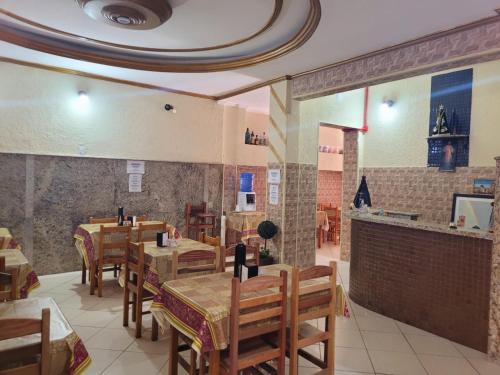 a restaurant with wooden tables and chairs in a room at Hotel Pousada Lega's in Aparecida