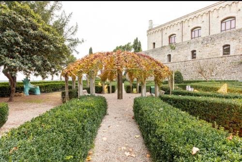 um jardim com árvores e arbustos em frente a um edifício em Residenza San Donato em Montepulciano