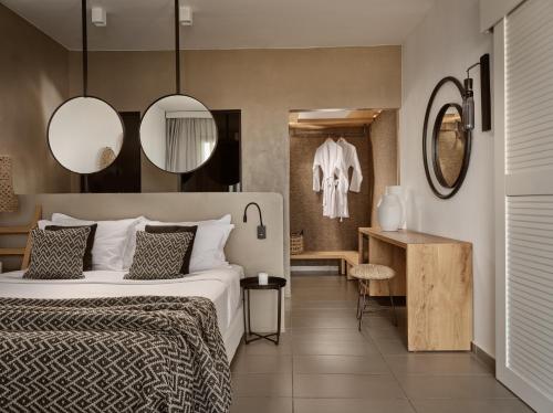 a bedroom with a bed and two mirrors at Seaside A Lifestyle Resort - Adults Only in Agia Pelagia