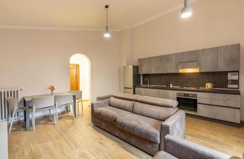 uma sala de estar com um sofá, uma mesa e uma cozinha em Residenza San Donato em Montepulciano
