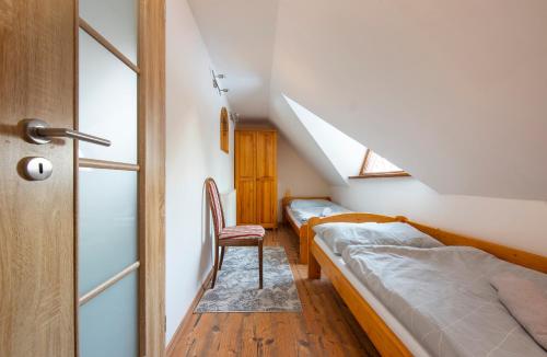 a bedroom with two beds and a chair in it at Wellness Vila Astra in Stará Lesná