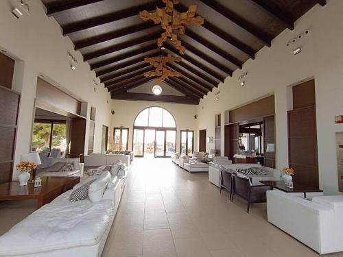 Cette grande chambre dispose de lits blancs, de tables et d'un plafond. dans l'établissement Villa privada Valle Golf Resort, à Murcie