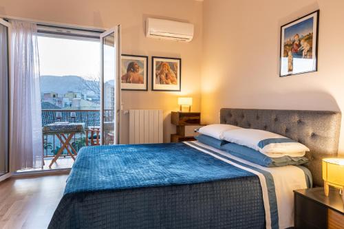 a bedroom with a bed and a balcony at La Paperella Blu Apartment in Termini Imerese