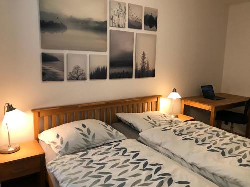 a bedroom with a bed and a desk with a laptop at Spacious apartment in the park in Košice