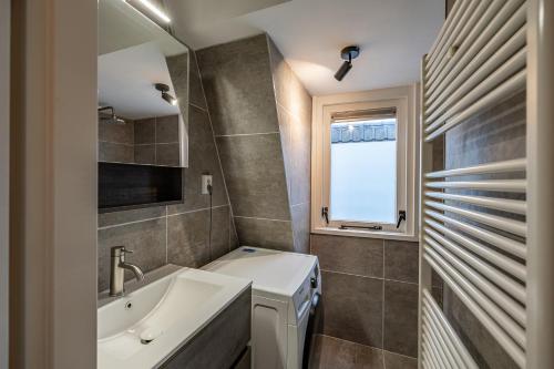een badkamer met een wastafel, een bad en een raam bij Luxe appartement in centrum van Groningen! in Groningen