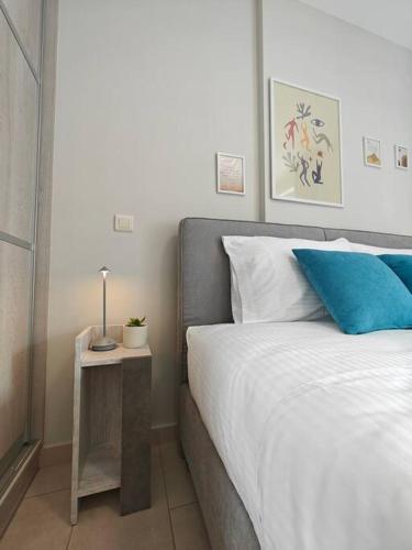 - une chambre avec un lit doté d'un oreiller bleu et d'une table dans l'établissement Margarita Flat, à Tripoli