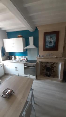 een woonkamer met een open haard en blauwe muren bij Studio cosy de Luc in Luc-sur-Mer
