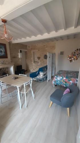 een woonkamer met een tafel en een bed bij Studio cosy de Luc in Luc-sur-Mer