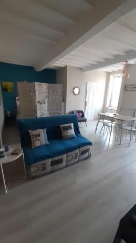 un soggiorno con divano blu e tavolo di Studio cosy de Luc a Luc-sur-Mer