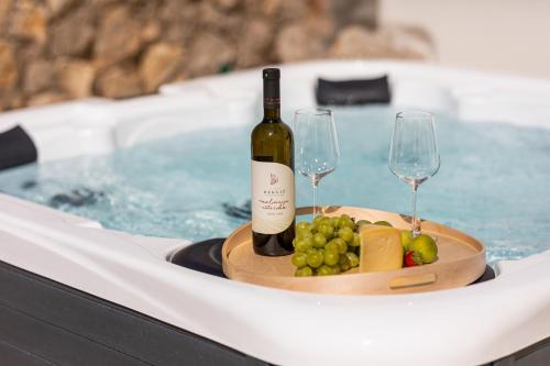 a bottle of wine and wine glasses in a hot tub at Hidden House Porta in Krk