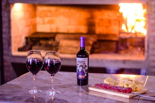 a bottle of wine and two wine glasses on a table at Hospedaje Patagonia Sur in Gobernador Gregores
