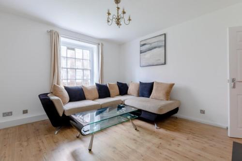 een woonkamer met een bank en een glazen tafel bij Inviting 2BD Flat 15 Minutes from Regents Park! in Londen