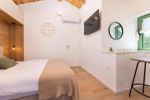 a bedroom with a bed and a sink and a mirror at Hidden House Porta in Krk