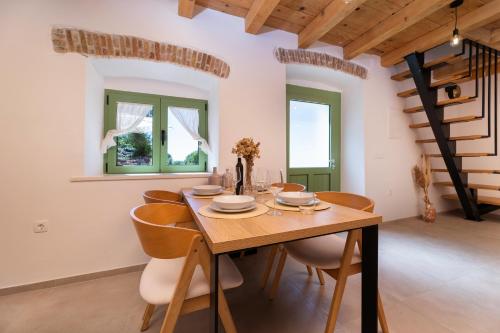 a dining room with a wooden table and chairs at Hidden House Porta in Krk