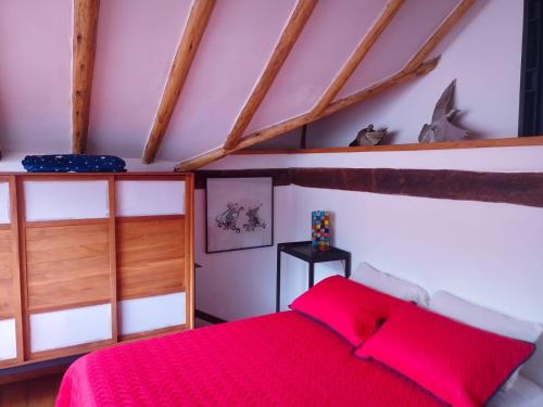 a bedroom with a red bed in a attic at Villa Monserrate Bed and Breakfast in Bogotá