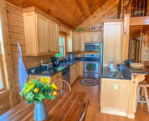 a kitchen with a vase of flowers on a table at Over The River in West Jefferson