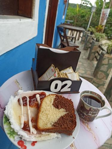 a plate of food with a sandwich and a cup of coffee at Casa da Marlene in Guaramiranga