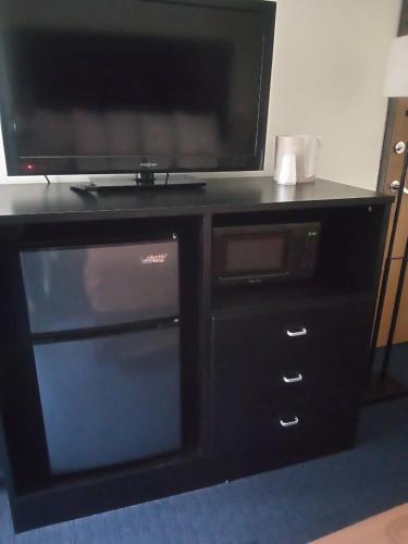 a black entertainment center with a tv and a microwave at FairBridge Inn & Suites Sunnyside in Sunnyside