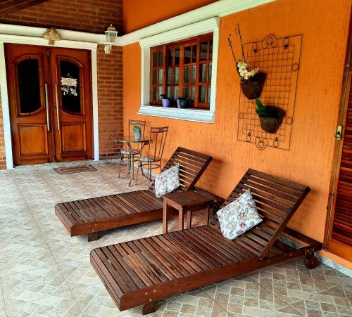 two benches sitting on a patio with a table at Toca - Bairro Serrano in São Bento do Sapucaí
