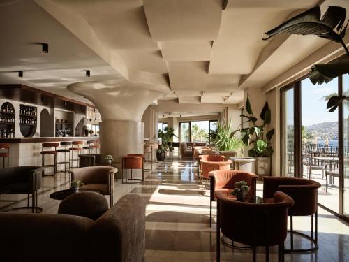 a lobby of a hotel with chairs and tables at Seaside A Lifestyle Resort - Adults Only in Agia Pelagia