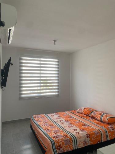 een bed in een kamer met een raam bij Apartamento Conjunto Aqualina Orange in Girardot