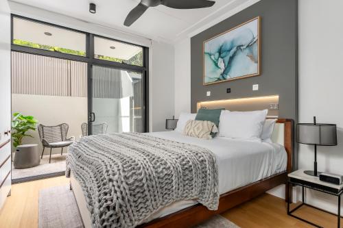 a bedroom with a bed and a large window at Barangaroo Park Apartments by Urban Rest in Sydney