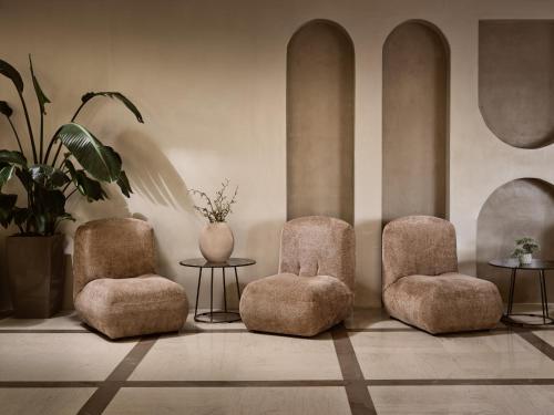 a room with three chairs and a table and a vase at Seaside A Lifestyle Resort - Adults Only in Agia Pelagia