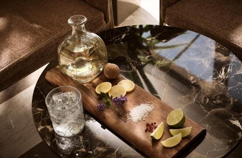 a table with a bottle of water and a cutting board with lemons at Seaside A Lifestyle Resort - Adults Only in Agia Pelagia