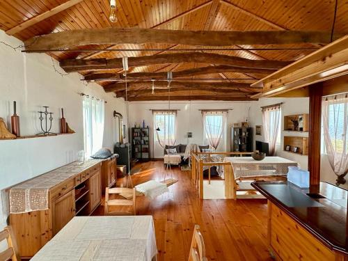 Casa Anjos Holiday Cottages في Areias: مطبخ وغرفة معيشة مع أرضيات وأسقف خشبية