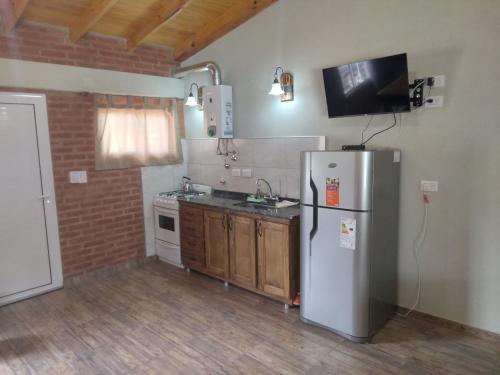 a kitchen with a refrigerator and a sink at Luz Alba Cabañas in Mina Clavero