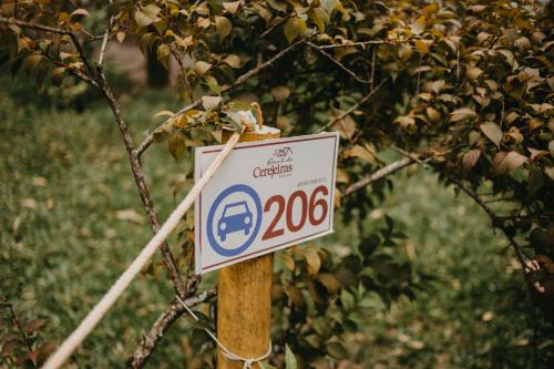 a sign on a wooden pole in a tree at Pousada Recanto das Cerejeiras in Rio Grande