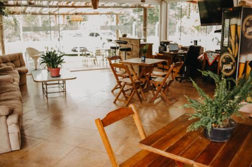 sala de estar con mesas, sillas y sofá en Pousada Recanto das Cerejeiras en Río Grande