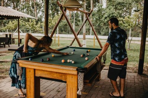 a man and a woman playing a game of pool at Pousada Recanto das Cerejeiras in Rio Grande