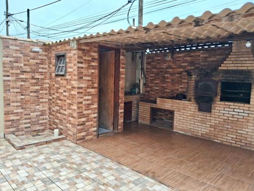 an open patio with a brick wall and a door at CABO FRIO, SUITES PÉ AREIA in Cabo Frio