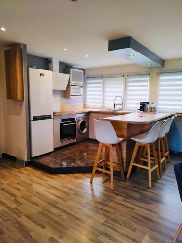 een keuken met een tafel en stoelen en een koelkast bij * Appartement Cosy - Fauriel - balcon & garage in Saint-Étienne