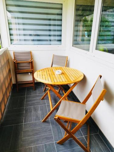 een tafel en stoelen op de veranda van een huis bij * Appartement Cosy - Fauriel - balcon & garage in Saint-Étienne