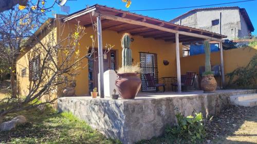 a yellow house with a large vase in front of it at La Inesita in Tafí del Valle
