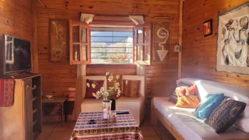 ein Wohnzimmer mit einem Sofa und einem Tisch in der Unterkunft La Inesita in Tafí del Valle