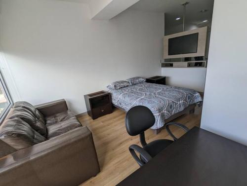 a living room with a bed and a couch at Suite studio Ph - Metro la Carolina in Quito