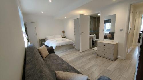 a living room with a couch and a bedroom at flat 2 Wimbledon in London
