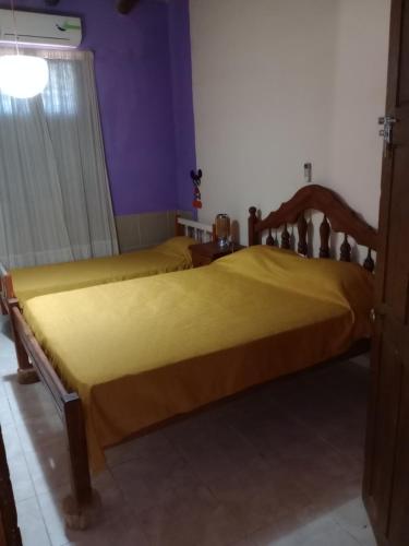2 camas en una habitación con paredes moradas en POSADA CUATRO HERMANOS en Tinogasta
