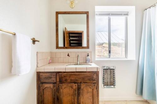 baño con lavabo, espejo y ventana en The Badger House, en Badger