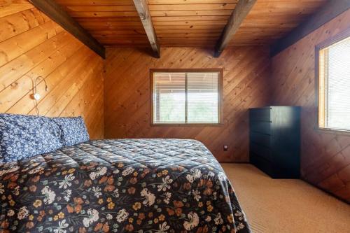 a bedroom with a bed in a room with wooden walls at The Badger House in Badger