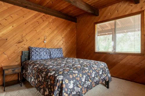 a bedroom with a bed in a room with wooden walls at The Badger House in Badger