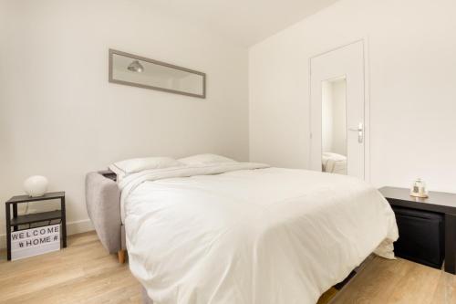 a white bedroom with a bed and a desk at Cozy Appart 4 Proche gare - Cozy Houses in Palaiseau