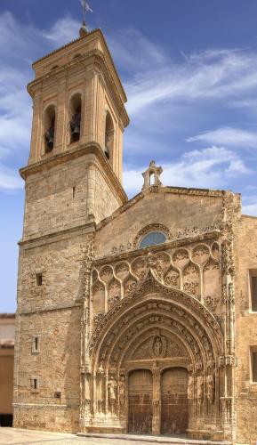 an old stone building with a clock tower and a gate at Apartamentos Bobal Requena in Requena