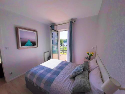 um quarto com uma cama e uma grande janela em Apartment Aqua Marina - Lake, Nature and Relax! em Iława