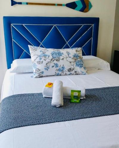 a bed with towels on it with a blue headboard at Pousada da Onça - Itapiranga, AM in Itapiranga